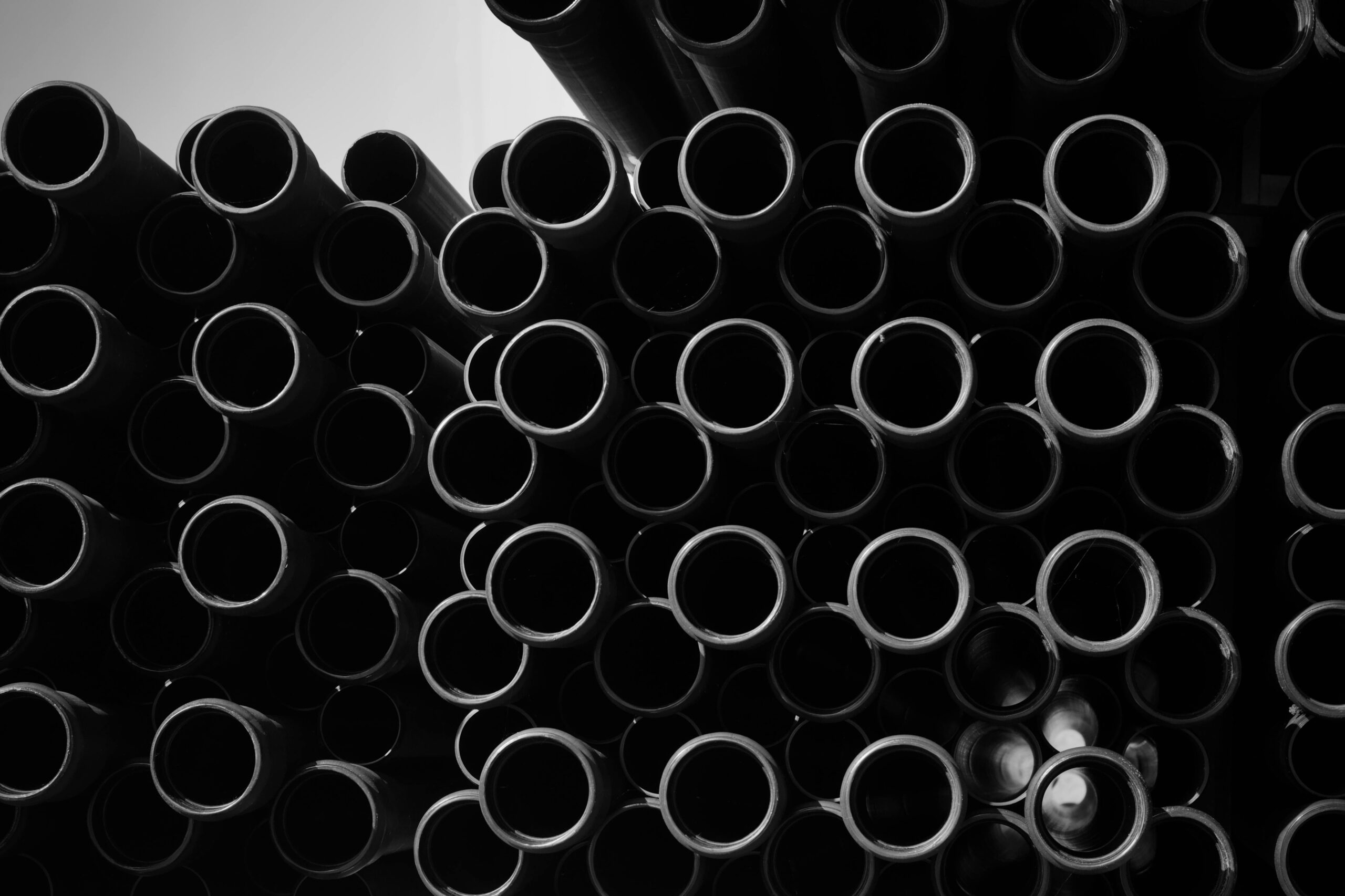 Artistic black and white image of stacked industrial pipes for creative projects.